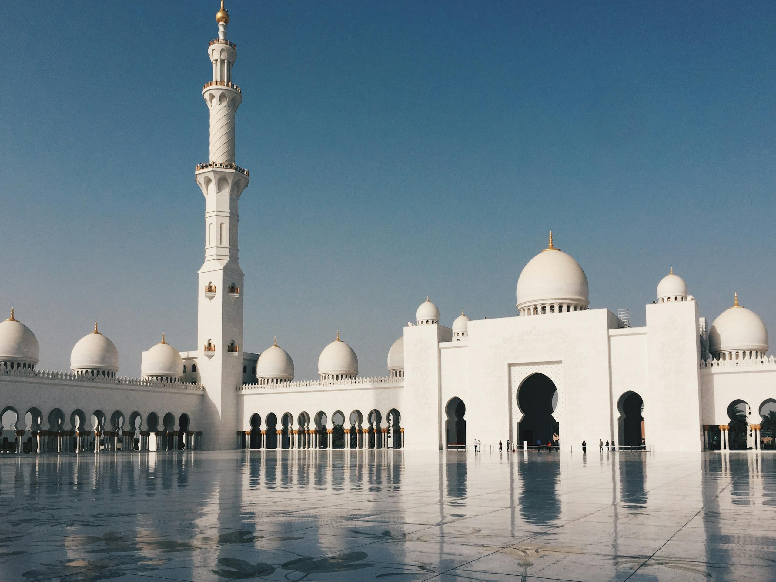 Beautiful view of Sheikh Zayed Grand Mosque with minarets and domes in Abu Dhabi under a clear blue sky.
